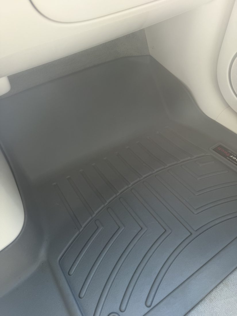 The same passenger floor mat after detailing — deep-cleaned back to factory finish