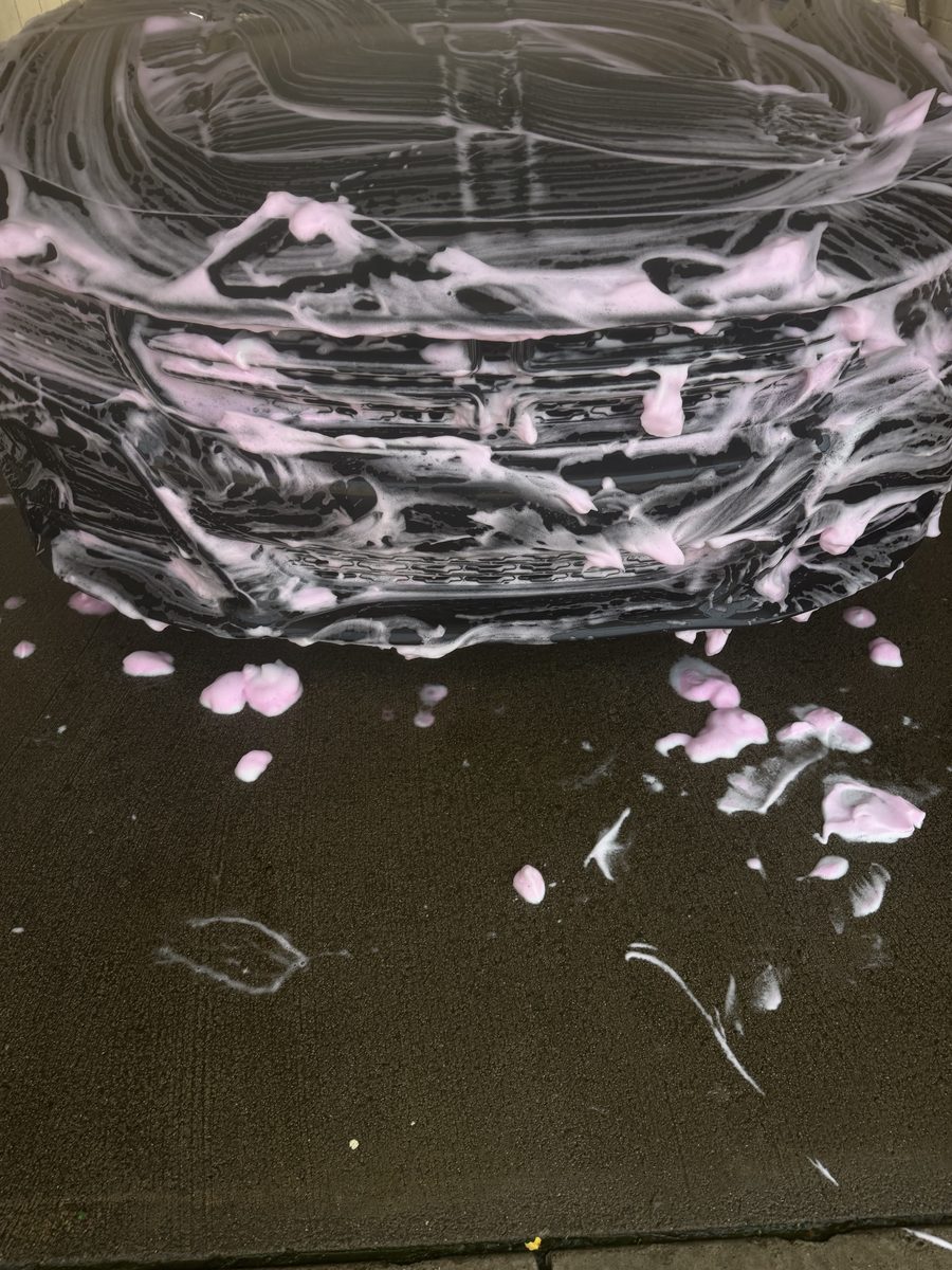 Foam covering the front grille and bumper of a Dodge Charger mid-wash